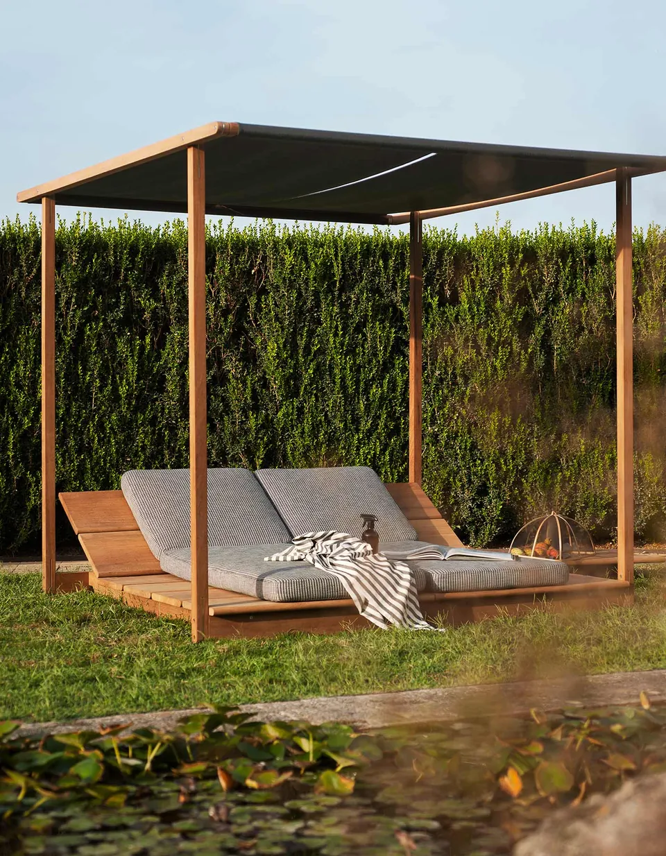 RODA Eolie sunloungers and gazebo beside a pool, RODA pool furniture catalog photograph