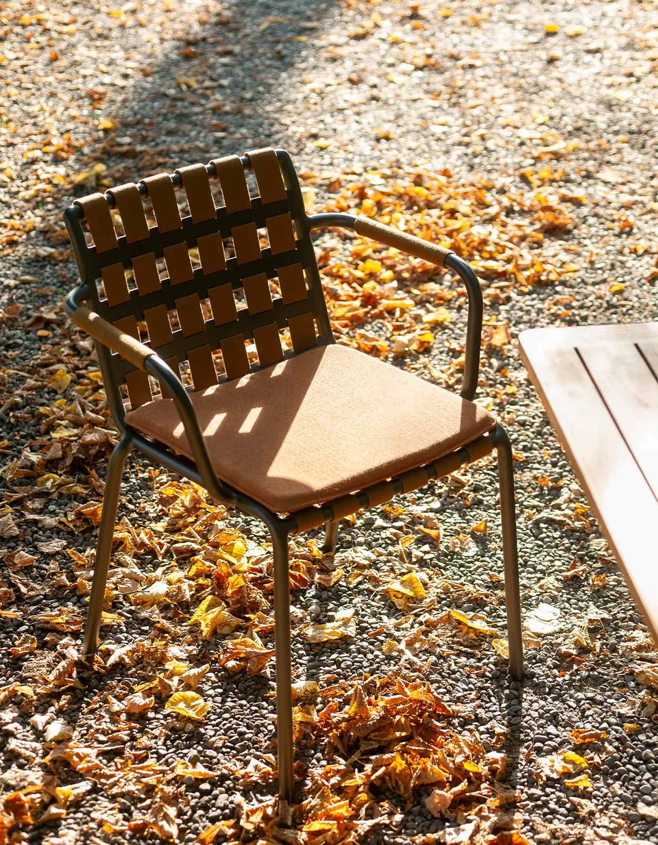 RODA Erice armchairs around an outdoor dining table, woven belt chair catalog photograph