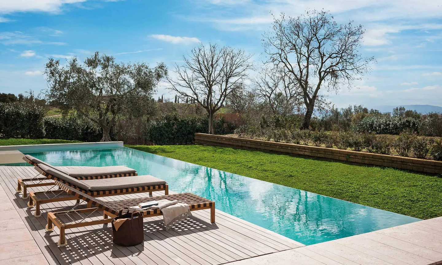 RODA Mistral teak sofa and sunloungers by a pool, Italian outdoor furniture catalog photograph