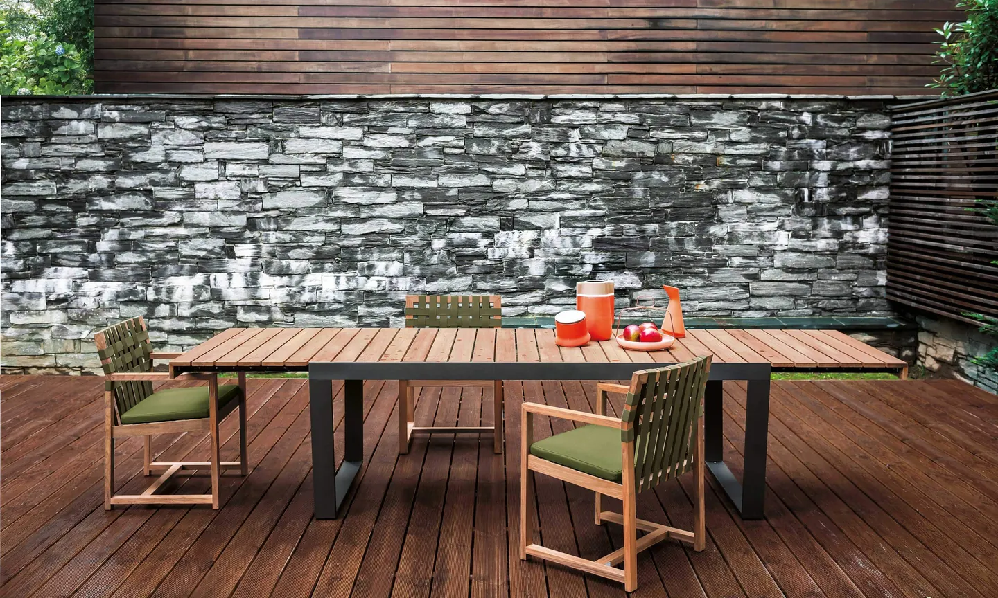 RODA Network teak sofa with shelf backrest and coffee table on a terrace, Italian outdoor furniture catalog photograph