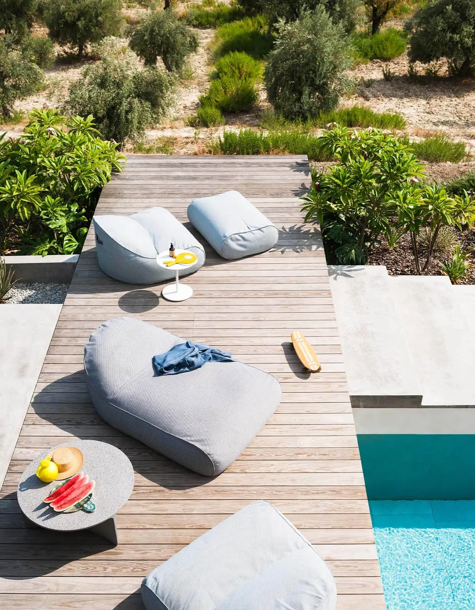 RODA Onda lounge chair, chaise longue and pouf on a pool deck, Italian outdoor furniture catalog photograph