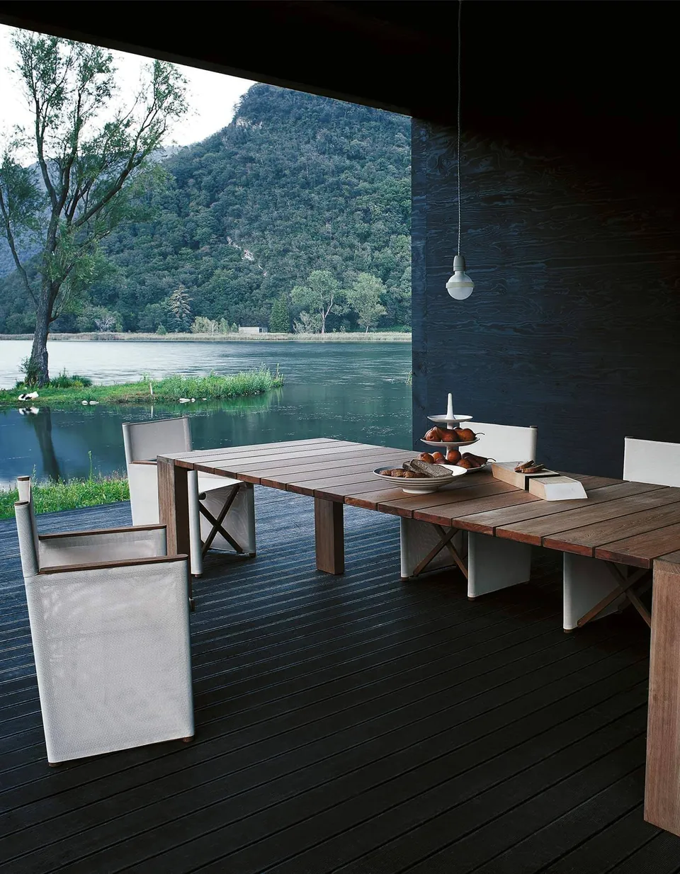 RODA Pier teak table under a covered terrace, RODA patio furniture catalog photograph