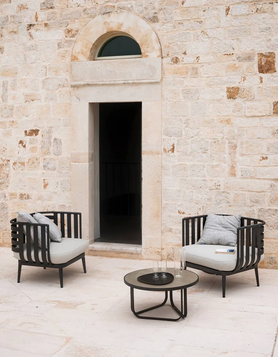 RODA Thea sofa and round coffee tables on a terrace, RODA patio furniture catalog photograph
