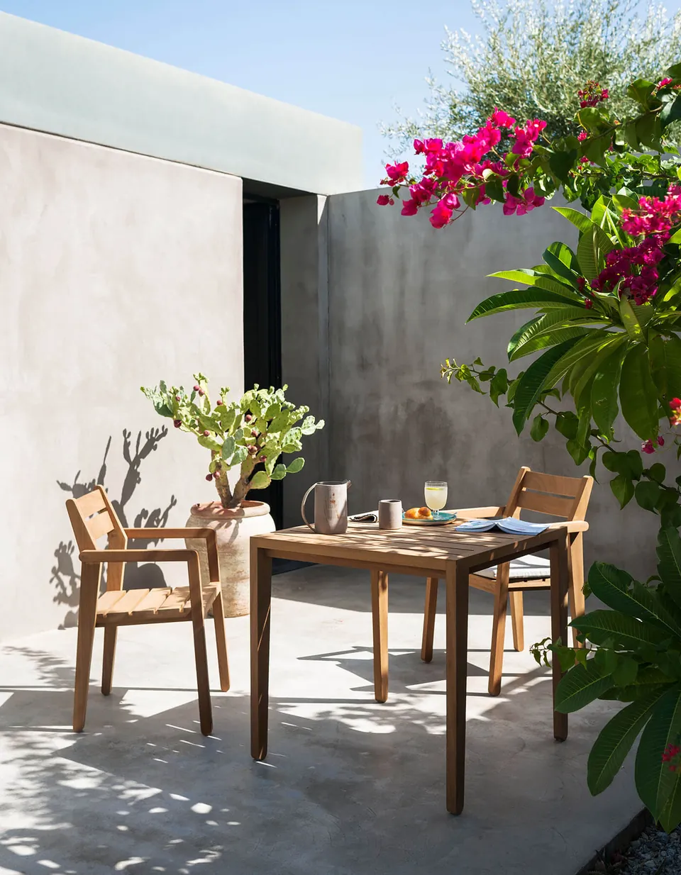 RODA Zania iroko chairs and table on a restaurant terrace, RODA furniture catalog photograph