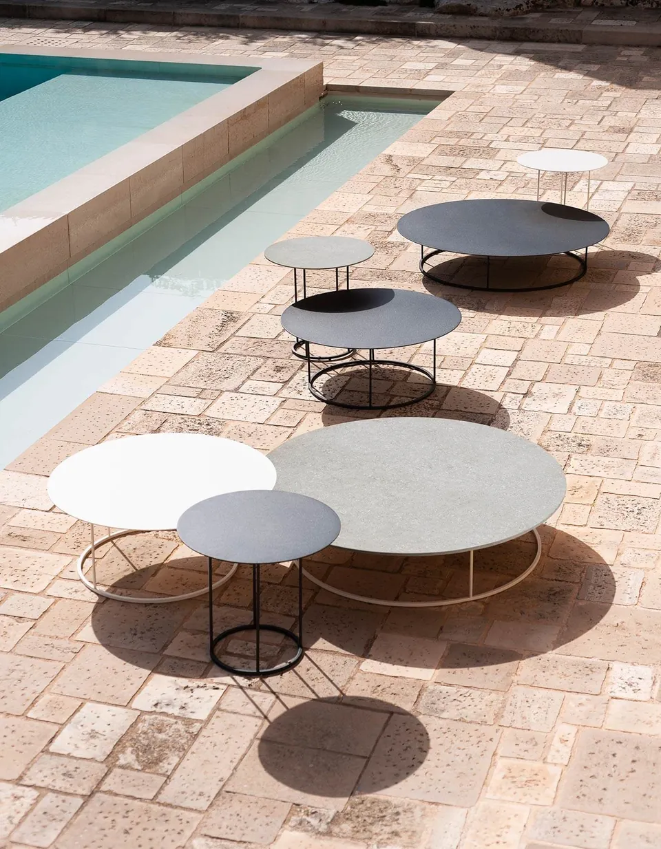 RODA Zefiro coffee tables in two sizes beside an outdoor sofa, RODA outdoor furniture catalog photograph